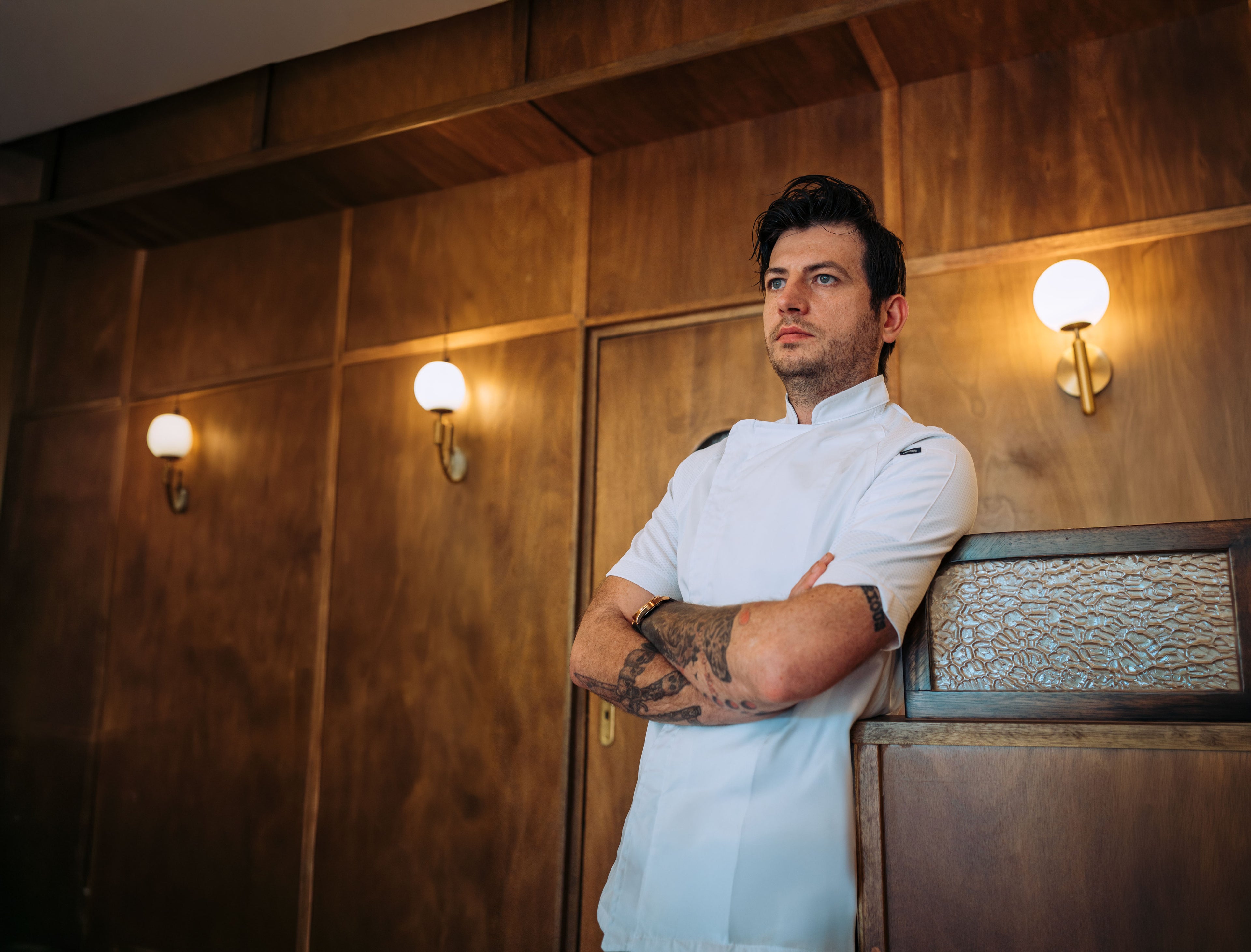 Man in a white chef's coat standing in a restaurant