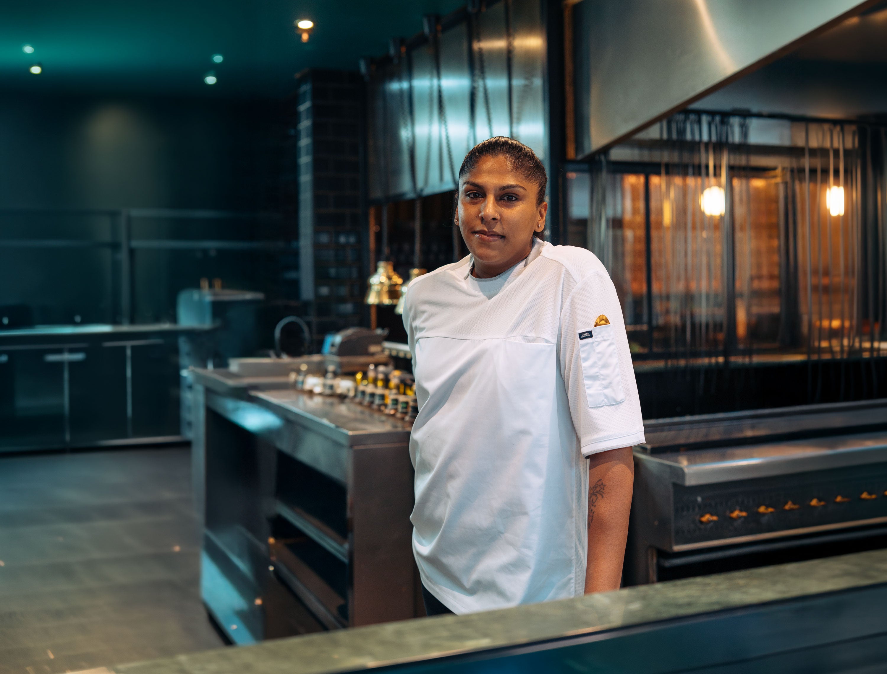 Person in a chef's uniform standing in a modern kitchen.